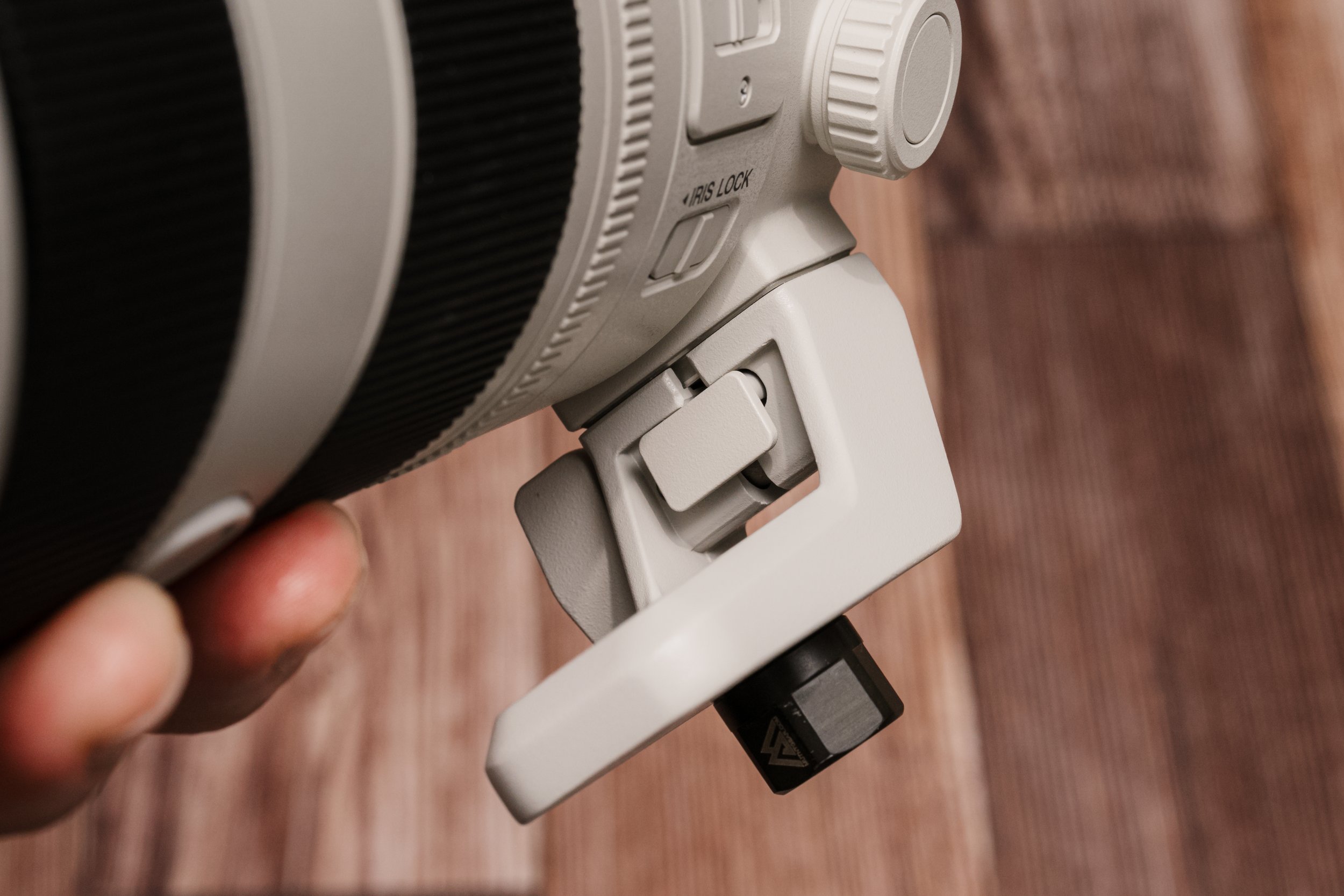 The removable tripod foot. No Arca-Swiss grooves, unfortunately, but it locks in positively. Here with a QD (quick-disconnect) sling adapter — the same system used on military rifles. This lens isn't going anywhere.